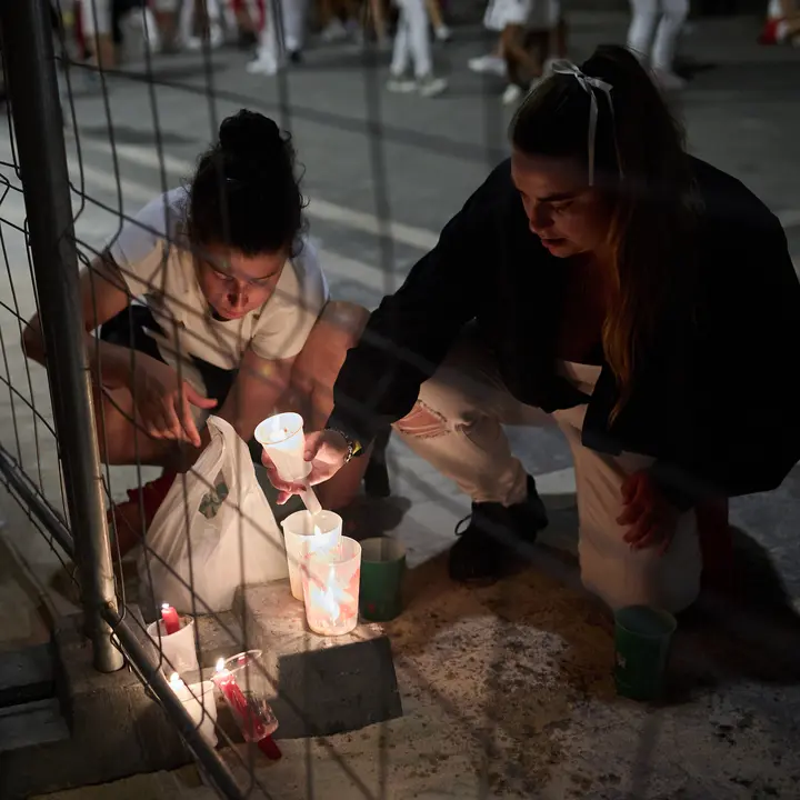 Cientos de personas depositan sus velas y pañuelos frente a la Iglesia de San Lorenzo momentos después del Pobre de mí con el que finalizan los nueve días de las Fiestas de San Fermín 2025. IÑIGO ALZUGARAY