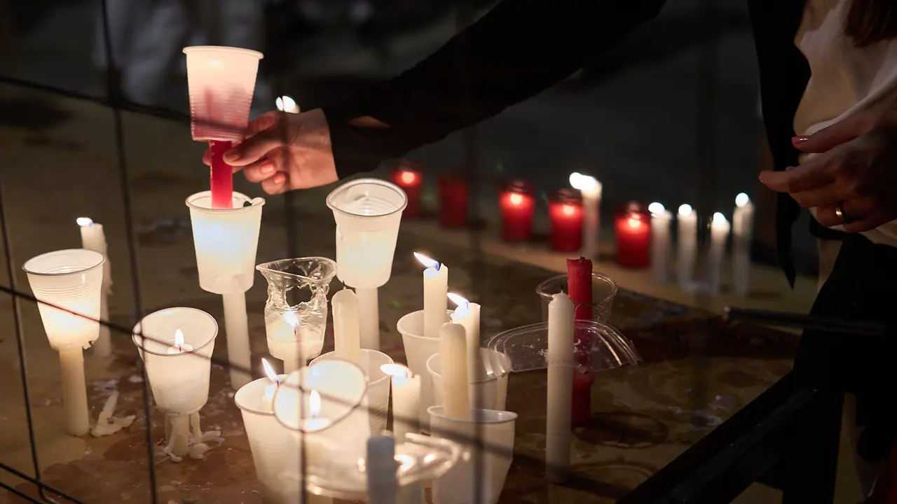 Cientos de personas depositan sus velas y pañuelos frente a la Iglesia de San Lorenzo momentos después del Pobre de mí con el que finalizan los nueve días de las Fiestas de San Fermín 2025. IÑIGO ALZUGARAY