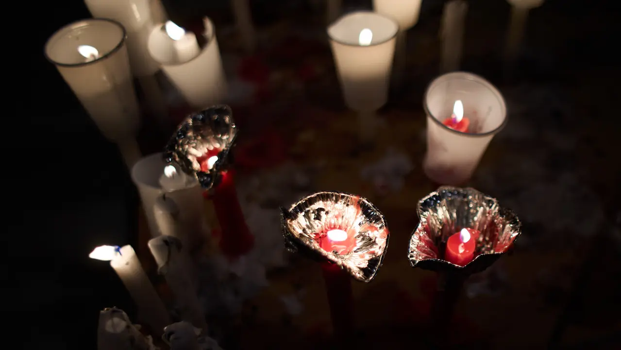 Cientos de personas depositan sus velas y pañuelos frente a la Iglesia de San Lorenzo momentos después del Pobre de mí con el que finalizan los nueve días de las Fiestas de San Fermín 2025. IÑIGO ALZUGARAY