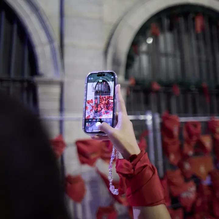 Cientos de personas depositan sus velas y pañuelos frente a la Iglesia de San Lorenzo momentos después del Pobre de mí con el que finalizan los nueve días de las Fiestas de San Fermín 2025. IÑIGO ALZUGARAY