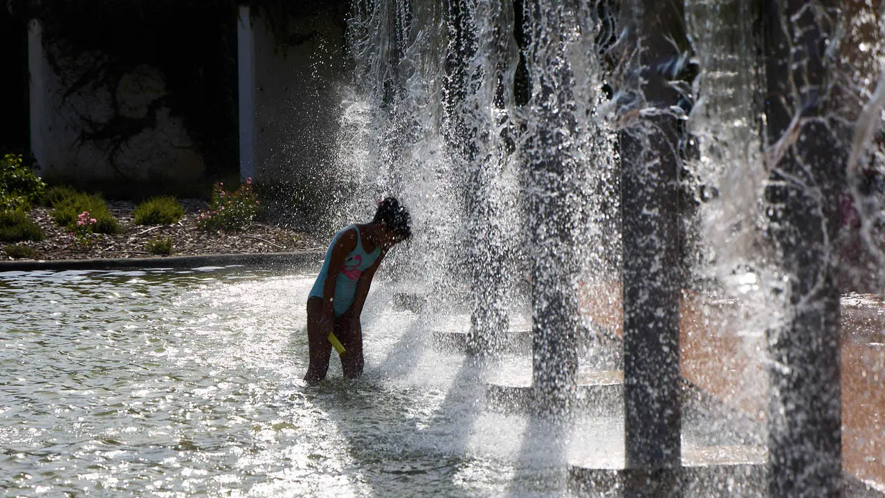 Unas niñas juegan con el agua en el parque de Yamaguchi de Pamplona durante la de calor de Agosto de 2025. IÑIGO ALZUGARAY