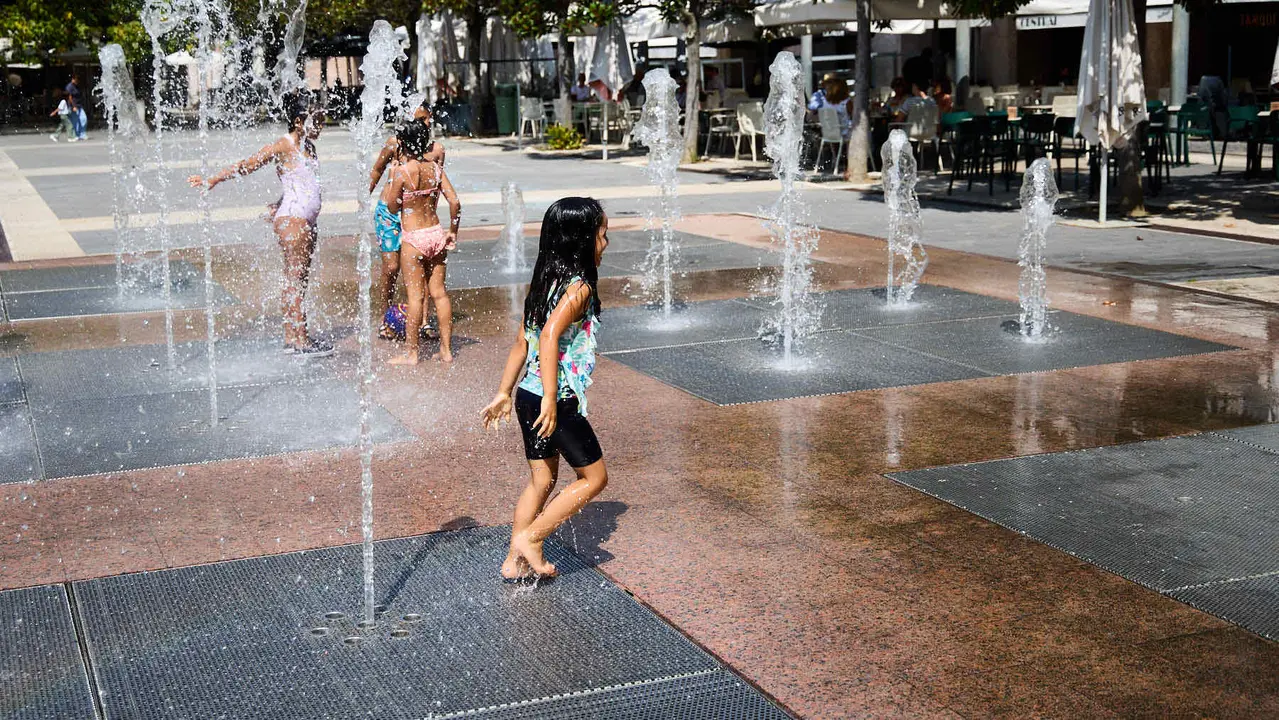 Niños y niñas juegan en la fuente de los chorros de Yamaguchi de Pamplona durante la de calor de Agosto de 2025. IÑIGO ALZUGARAY