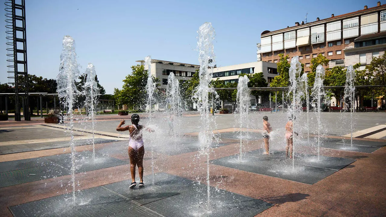 Niños y niñas juegan en la fuente de los chorros de Yamaguchi de Pamplona durante la de calor de Agosto de 2025. IÑIGO ALZUGARAY