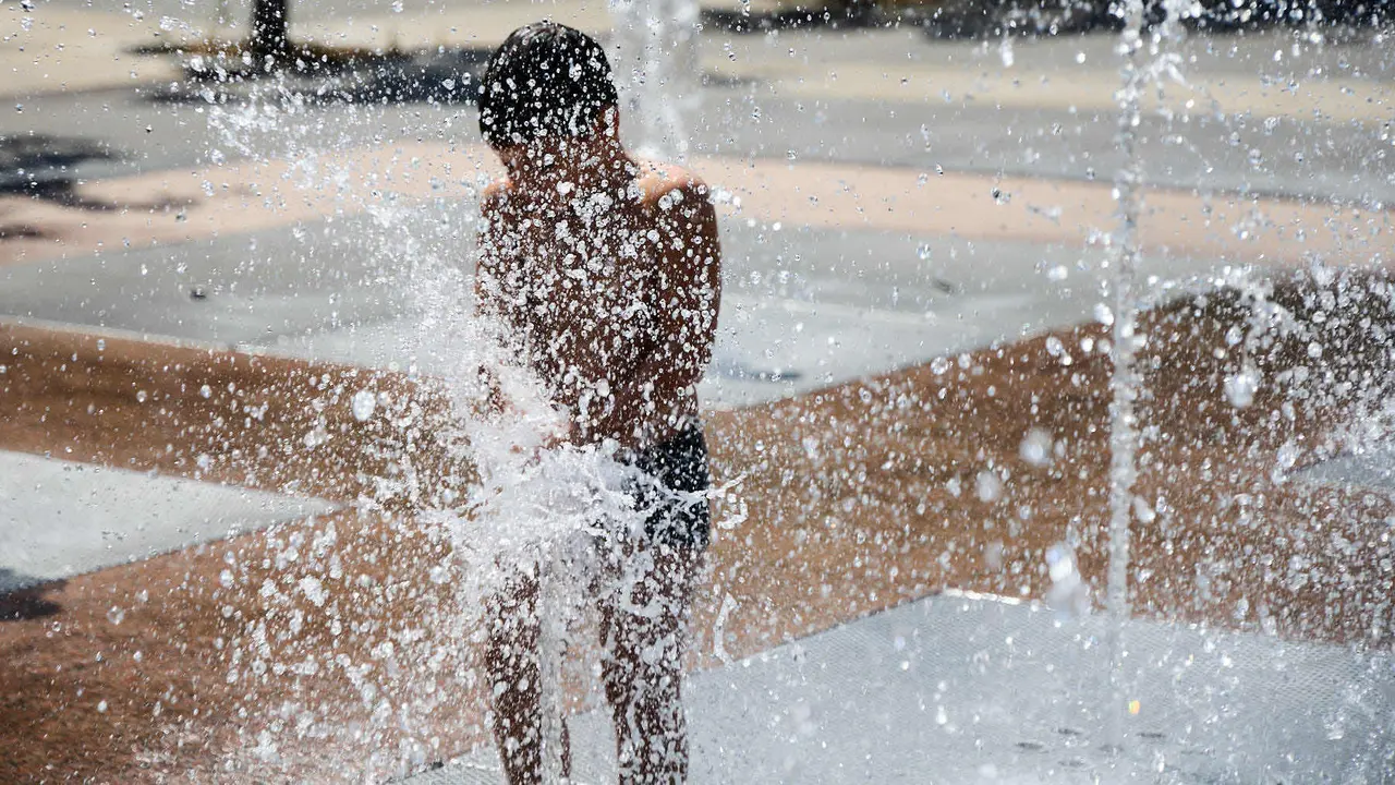 Niños y niñas juegan en la fuente de los chorros de Yamaguchi de Pamplona durante la de calor de Agosto de 2025. IÑIGO ALZUGARAY
