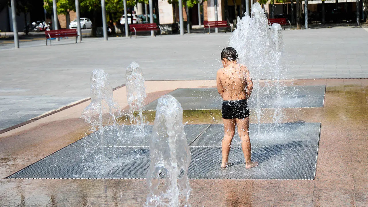 Niños y niñas juegan en la fuente de los chorros de Yamaguchi de Pamplona durante la de calor de Agosto de 2025. IÑIGO ALZUGARAY