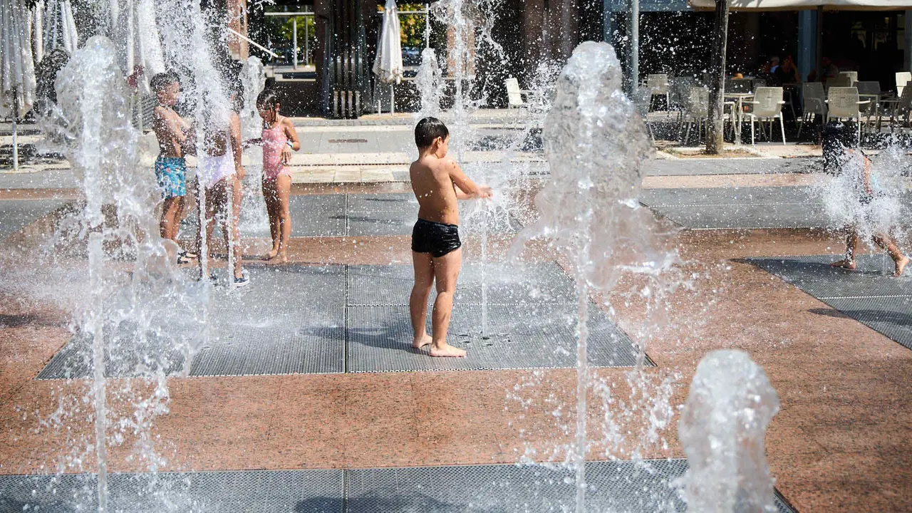 Niños y niñas juegan en la fuente de los chorros de Yamaguchi de Pamplona durante la de calor de Agosto de 2025. IÑIGO ALZUGARAY