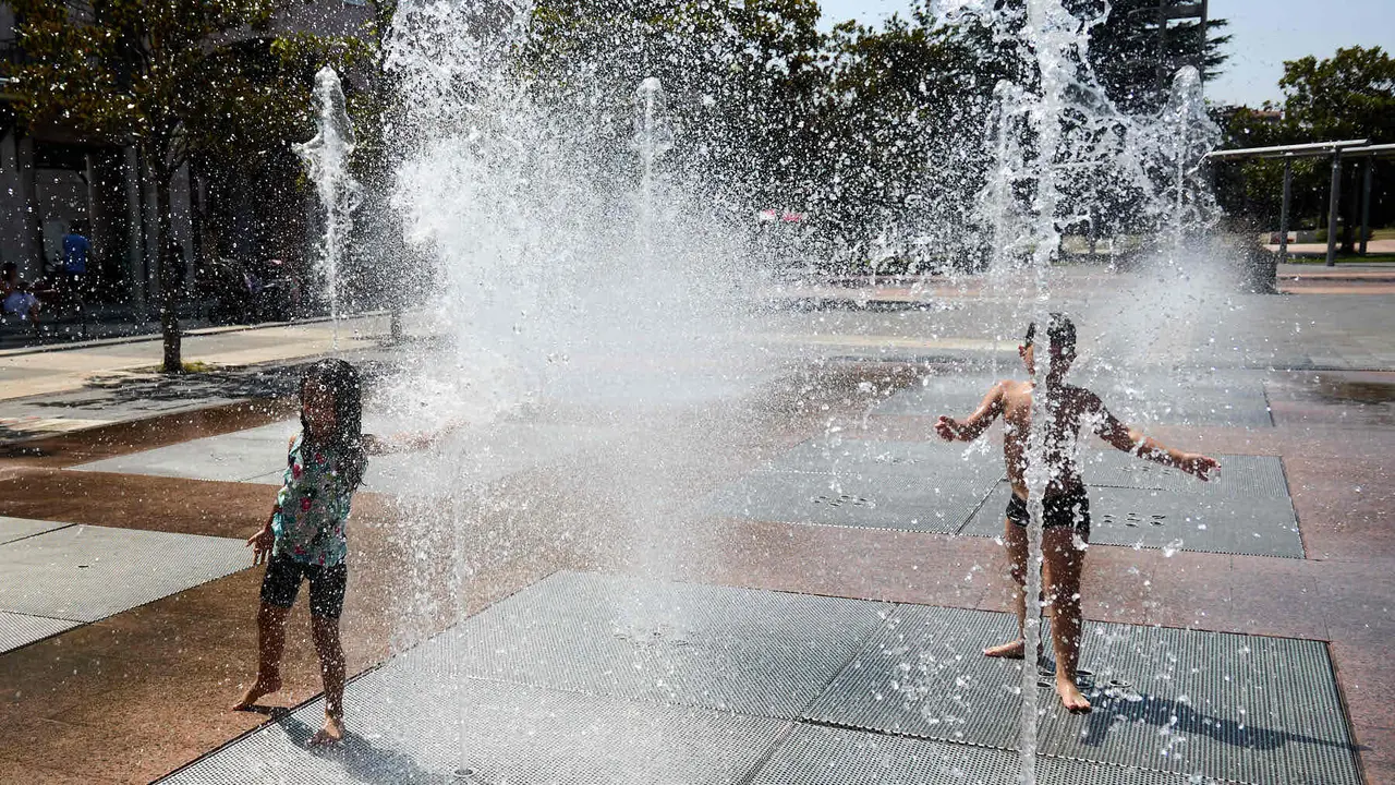 Niños y niñas juegan en la fuente de los chorros de Yamaguchi de Pamplona durante la de calor de Agosto de 2025. IÑIGO ALZUGARAY