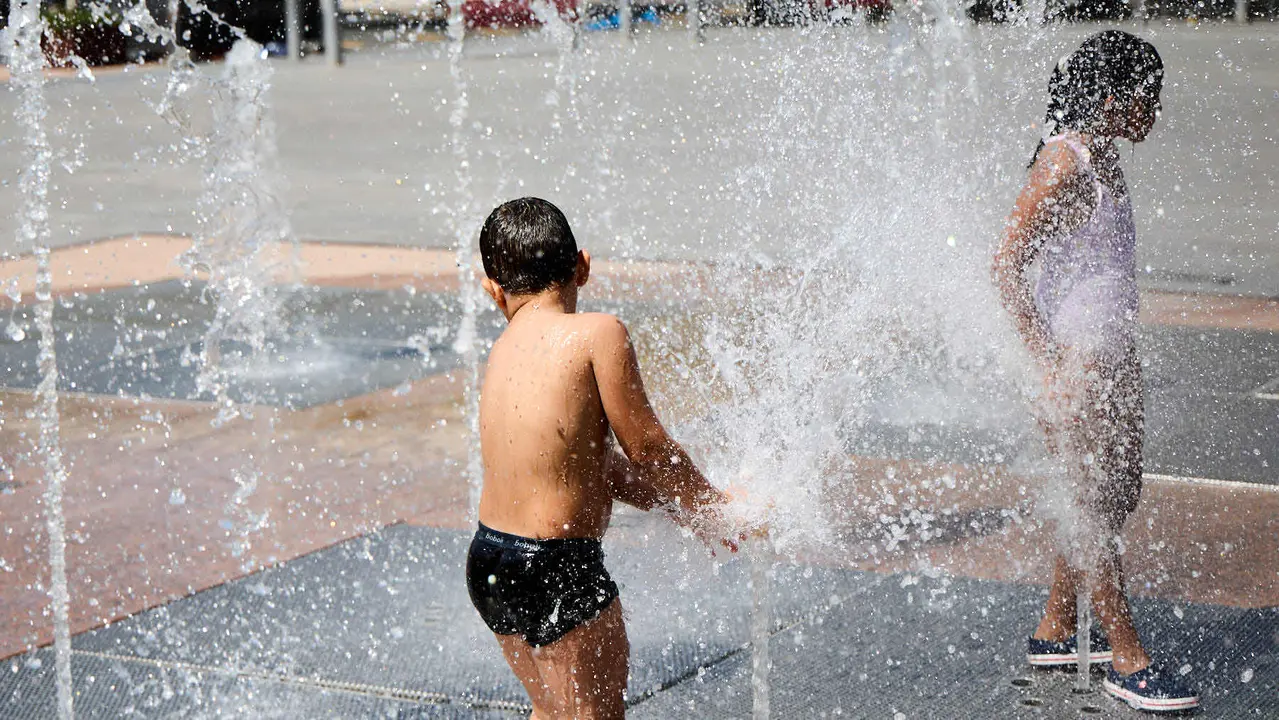 Niños y niñas juegan en la fuente de los chorros de Yamaguchi de Pamplona durante la de calor de Agosto de 2025. IÑIGO ALZUGARAY