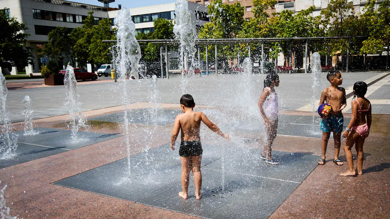 Niños y niñas juegan en la fuente de los chorros de Yamaguchi de Pamplona durante la de calor de Agosto de 2025. IÑIGO ALZUGARAY