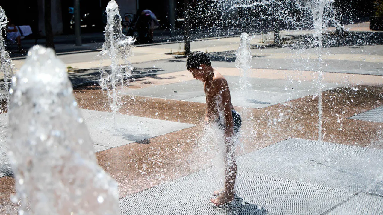 Niños y niñas juegan en la fuente de los chorros de Yamaguchi de Pamplona durante la de calor de Agosto de 2025. IÑIGO ALZUGARAY