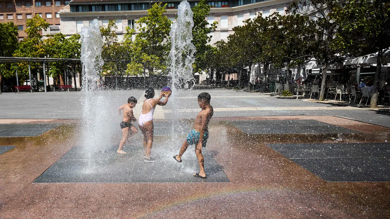 Niños y niñas juegan en la fuente de los chorros de Yamaguchi de Pamplona durante la de calor de Agosto de 2025. IÑIGO ALZUGARAY