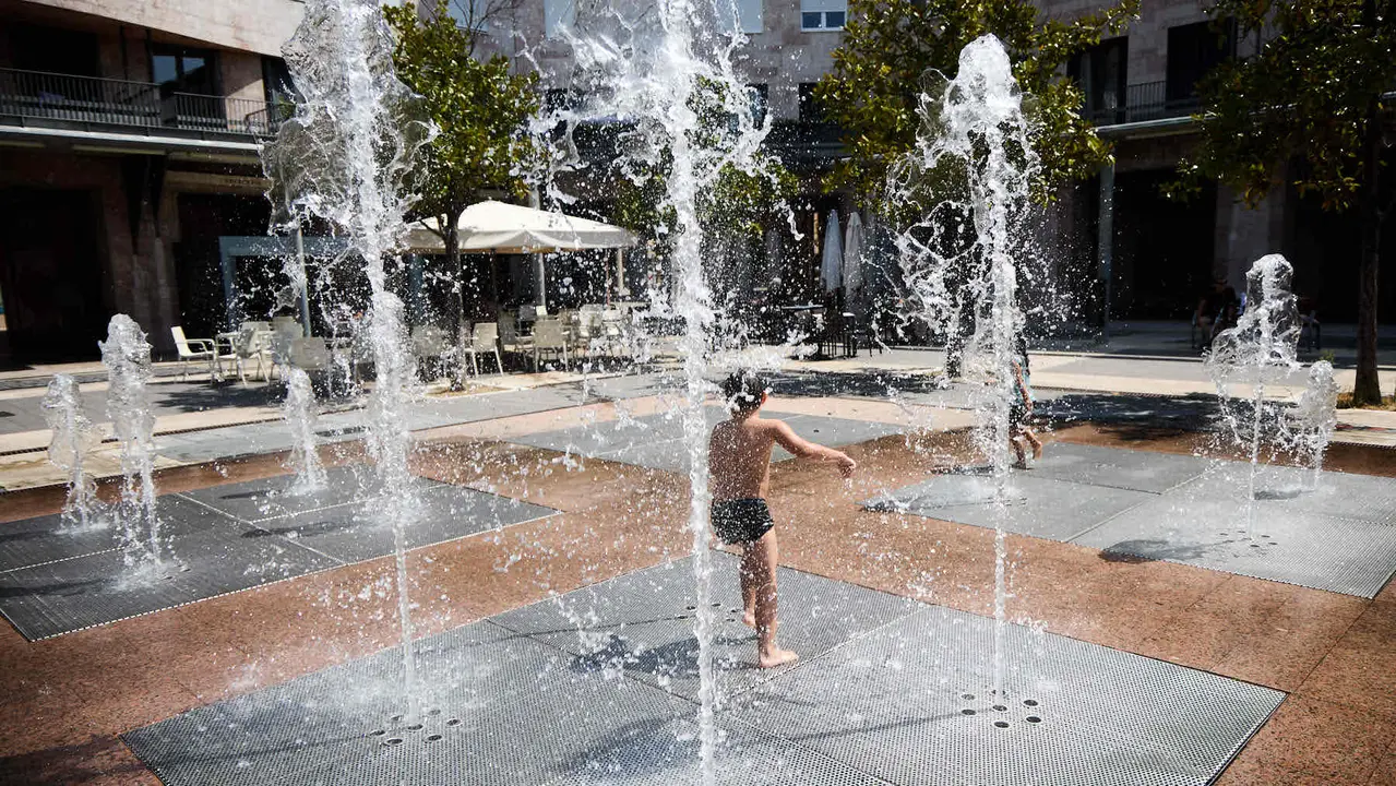 Niños y niñas juegan en la fuente de los chorros de Yamaguchi de Pamplona durante la de calor de Agosto de 2025. IÑIGO ALZUGARAY