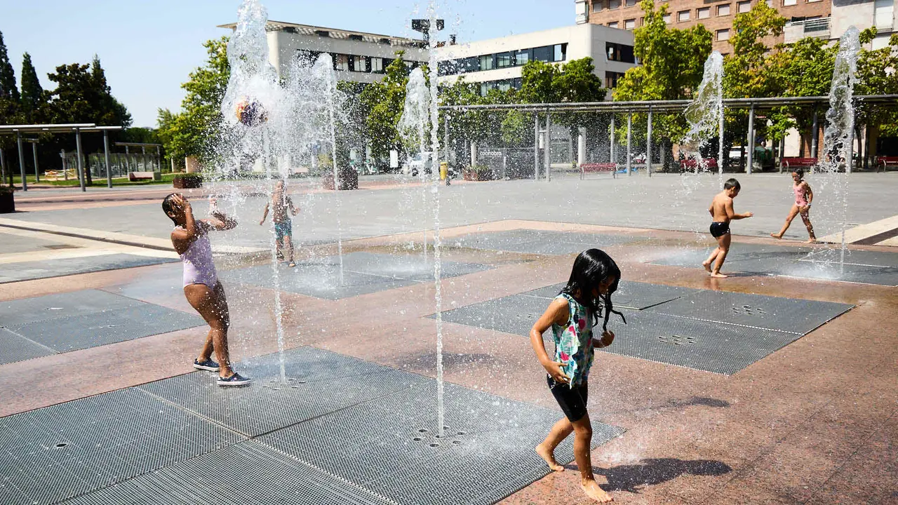 Niños y niñas juegan en la fuente de los chorros de Yamaguchi de Pamplona durante la de calor de Agosto de 2025. IÑIGO ALZUGARAY