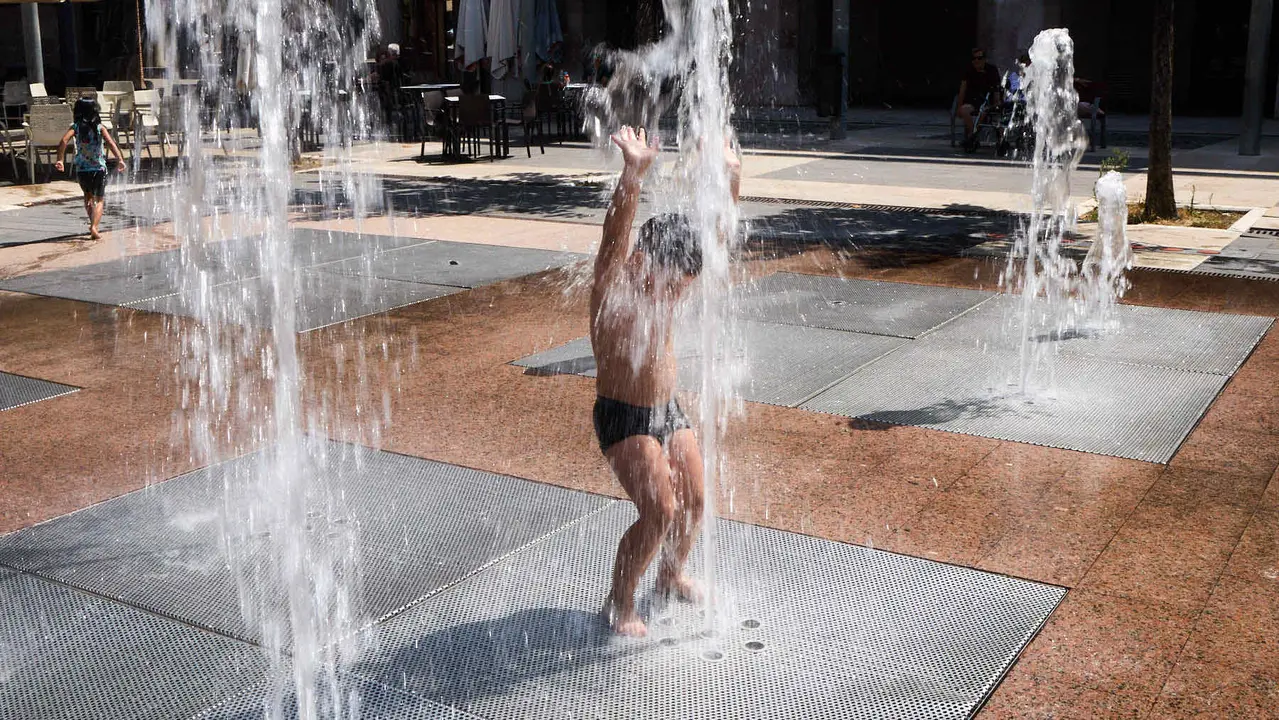 Niños y niñas juegan en la fuente de los chorros de Yamaguchi de Pamplona durante la de calor de Agosto de 2025. IÑIGO ALZUGARAY