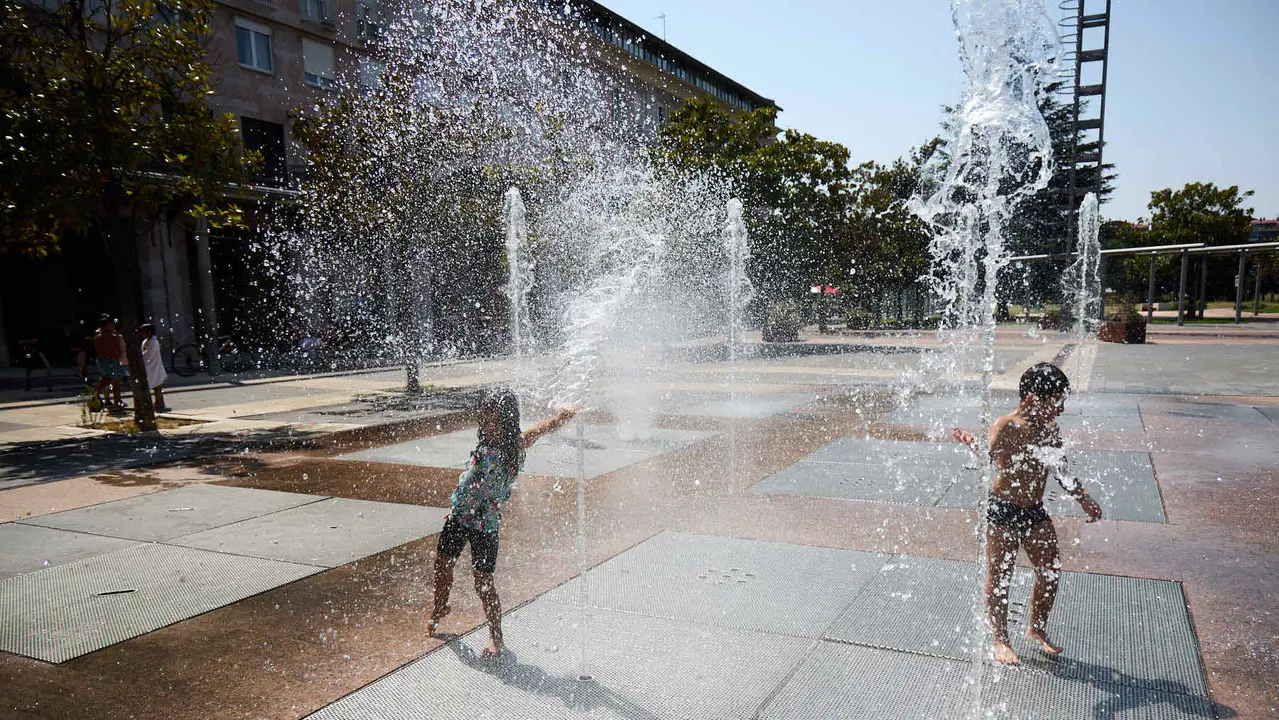 Niños y niñas juegan en la fuente de los chorros de Yamaguchi de Pamplona durante la de calor de Agosto de 2025. IÑIGO ALZUGARAY