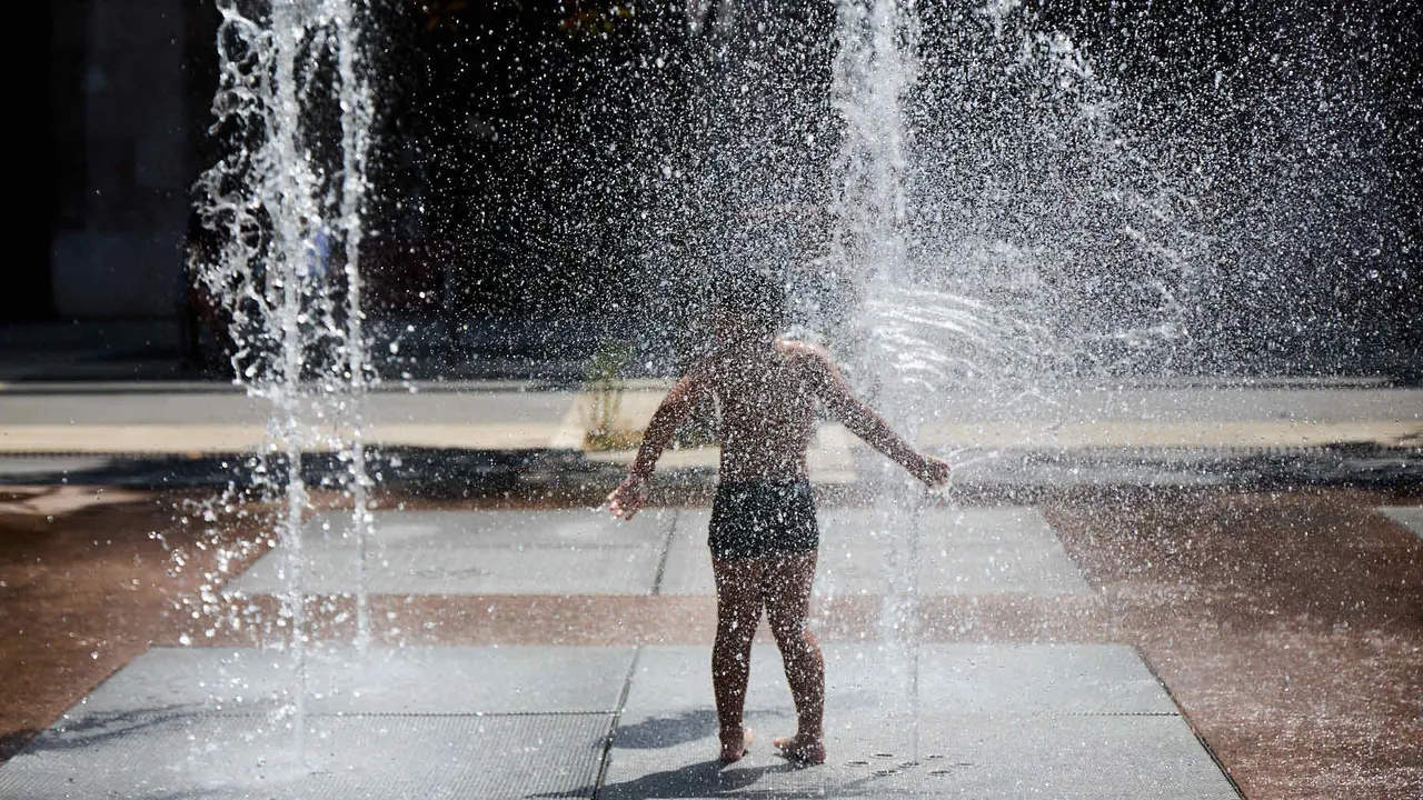 Niños y niñas juegan en la fuente de los chorros de Yamaguchi de Pamplona durante la de calor de Agosto de 2025. IÑIGO ALZUGARAY
