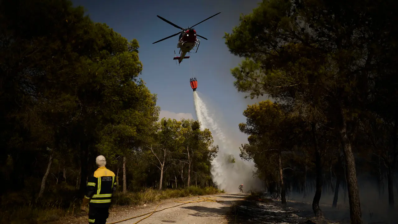 Efectivos de Bomberos, Policía Foral, Guardia Civil, aviones y helicópteros trabajan para sofocar el incendio forestal declarado en Carcastillo. PABLO LASAOSA