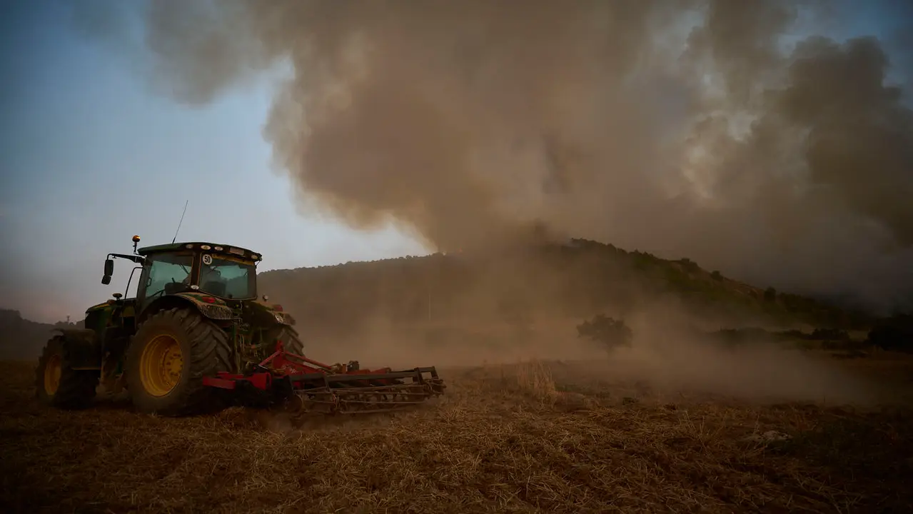 Efectivos de Bomberos, Policía Foral, Guardia Civil, aviones y helicópteros trabajan para sofocar el incendio forestal declarado en Carcastillo. PABLO LASAOSA