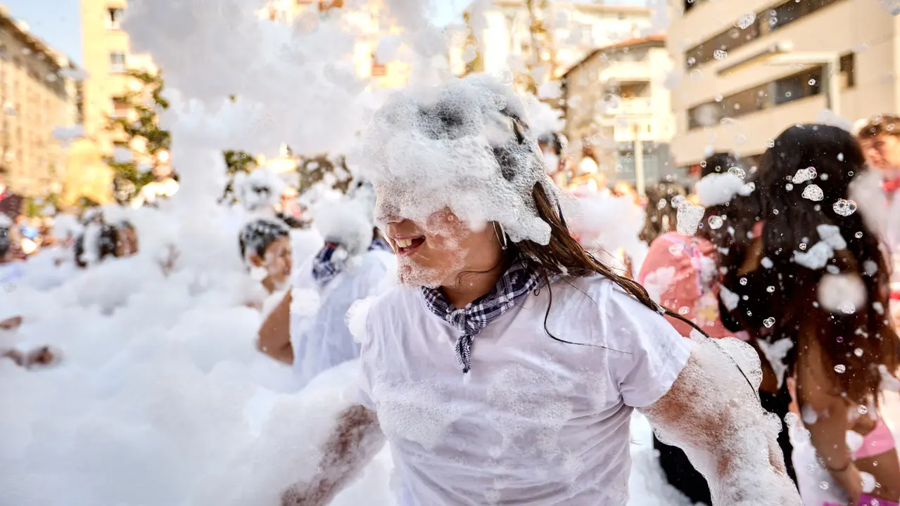 Niños y niñas juegan en la fiesta de la espuma tras el chupinazo de inicio de las Fiestas de Burlada 2025. IÑIGO ALZUGARAY