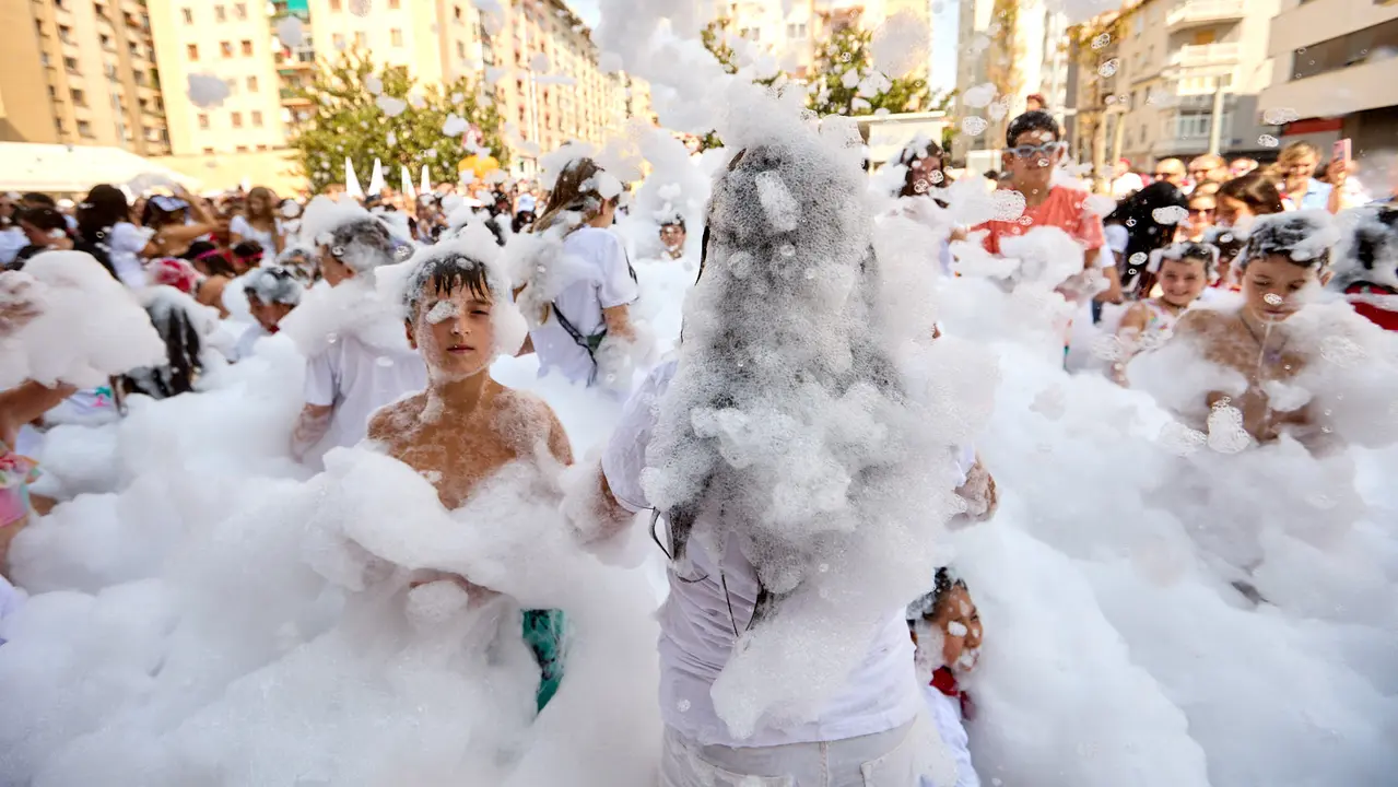 Niños y niñas juegan en la fiesta de la espuma tras el chupinazo de inicio de las Fiestas de Burlada 2025. IÑIGO ALZUGARAY