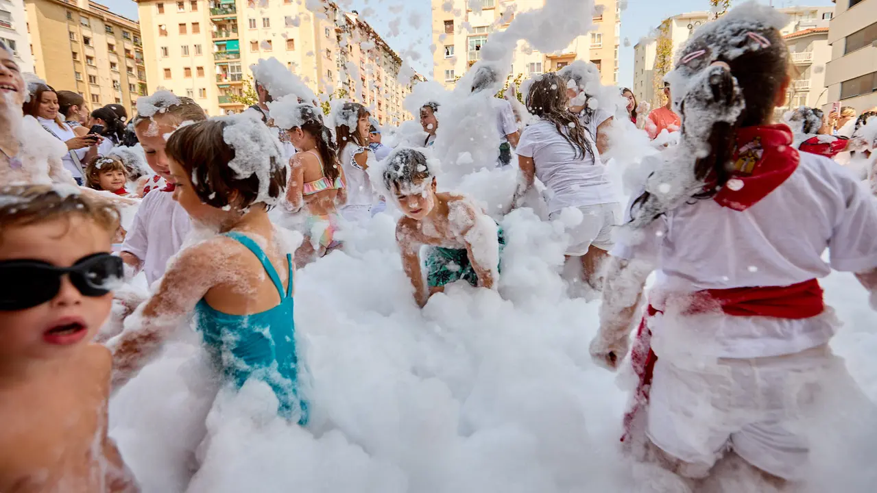 Niños y niñas juegan en la fiesta de la espuma tras el chupinazo de inicio de las Fiestas de Burlada 2025. IÑIGO ALZUGARAY