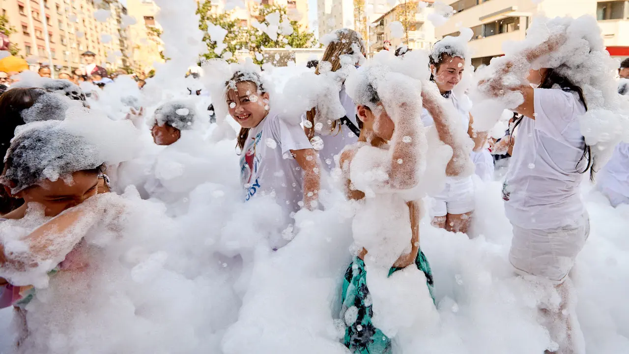 Niños y niñas juegan en la fiesta de la espuma tras el chupinazo de inicio de las Fiestas de Burlada 2025. IÑIGO ALZUGARAY