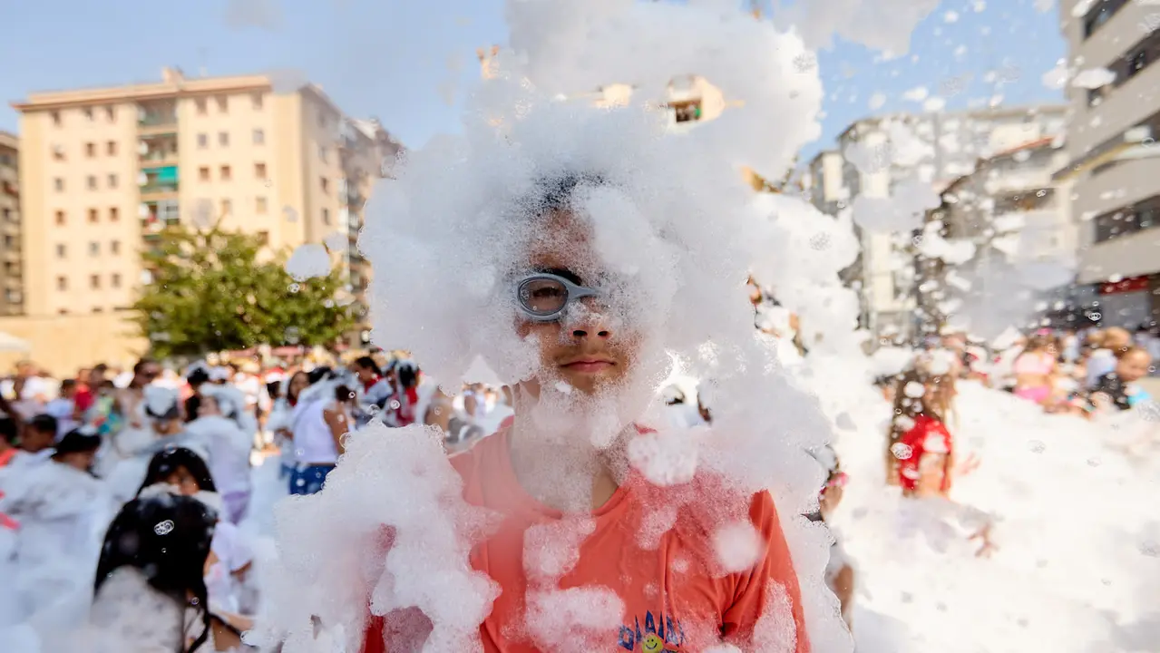 Niños y niñas juegan en la fiesta de la espuma tras el chupinazo de inicio de las Fiestas de Burlada 2025. IÑIGO ALZUGARAY