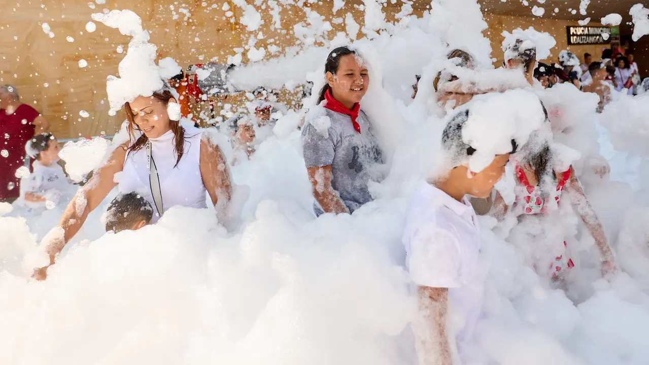 Niños y niñas juegan en la fiesta de la espuma tras el chupinazo de inicio de las Fiestas de Burlada 2025. IÑIGO ALZUGARAY