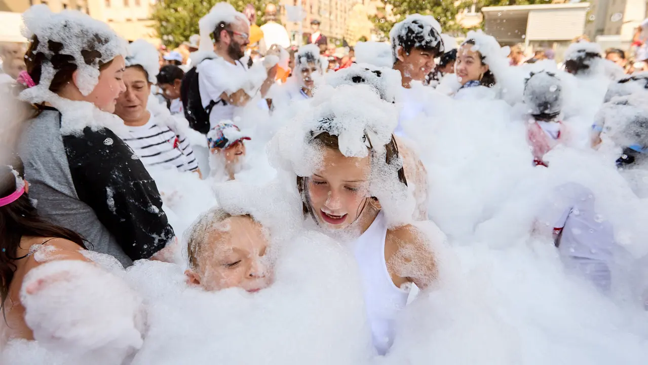 Niños y niñas juegan en la fiesta de la espuma tras el chupinazo de inicio de las Fiestas de Burlada 2025. IÑIGO ALZUGARAY