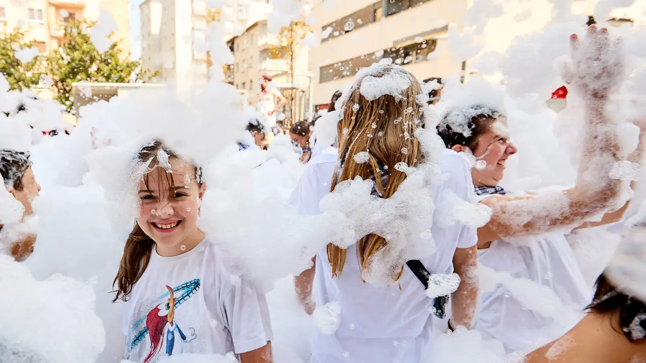 Niños y niñas juegan en la fiesta de la espuma tras el chupinazo de inicio de las Fiestas de Burlada 2025. IÑIGO ALZUGARAY