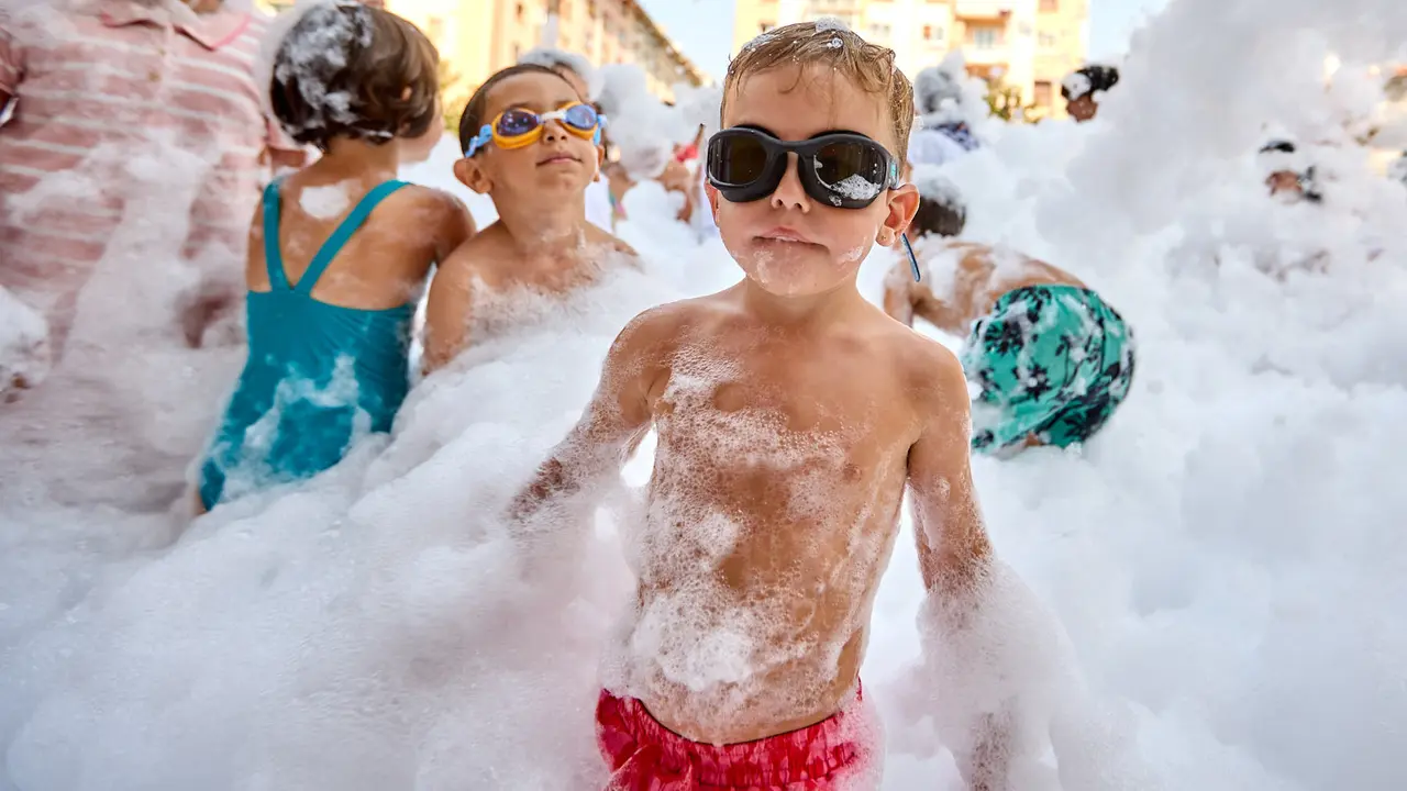 Niños y niñas juegan en la fiesta de la espuma tras el chupinazo de inicio de las Fiestas de Burlada 2025. IÑIGO ALZUGARAY