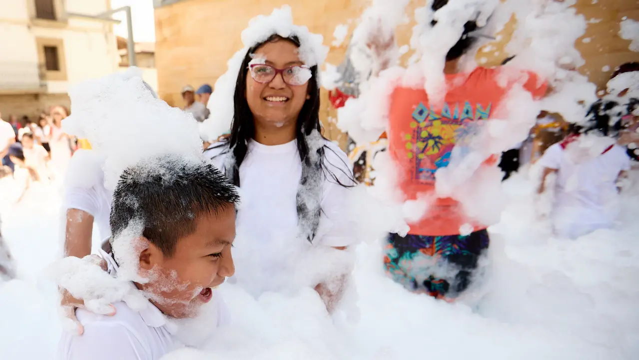 Niños y niñas juegan en la fiesta de la espuma tras el chupinazo de inicio de las Fiestas de Burlada 2025. IÑIGO ALZUGARAY