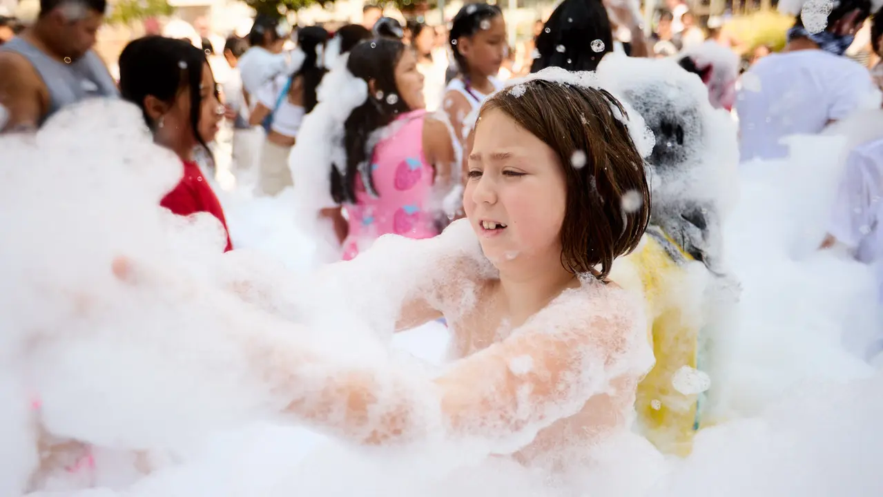 Niños y niñas juegan en la fiesta de la espuma tras el chupinazo de inicio de las Fiestas de Burlada 2025. IÑIGO ALZUGARAY