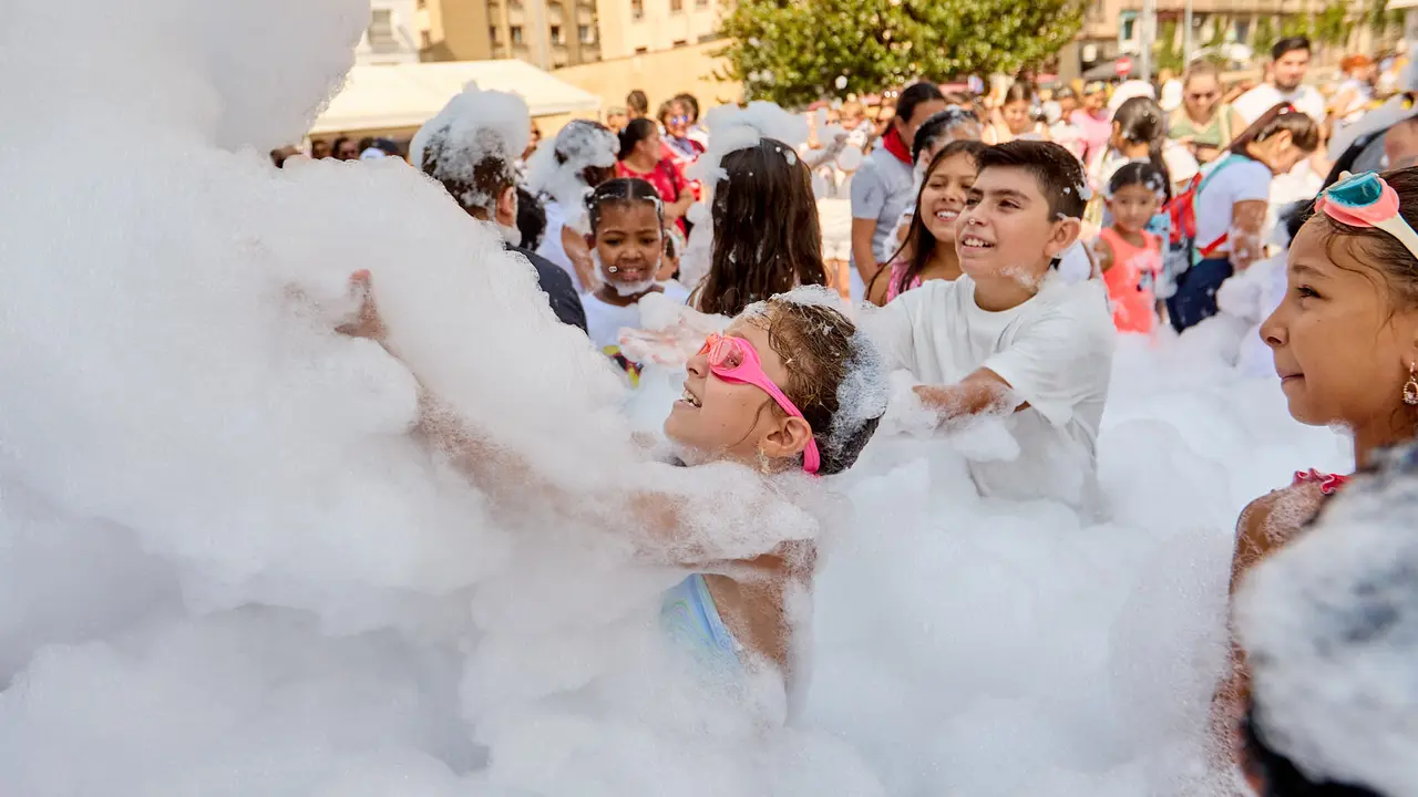 Niños y niñas juegan en la fiesta de la espuma tras el chupinazo de inicio de las Fiestas de Burlada 2025. IÑIGO ALZUGARAY