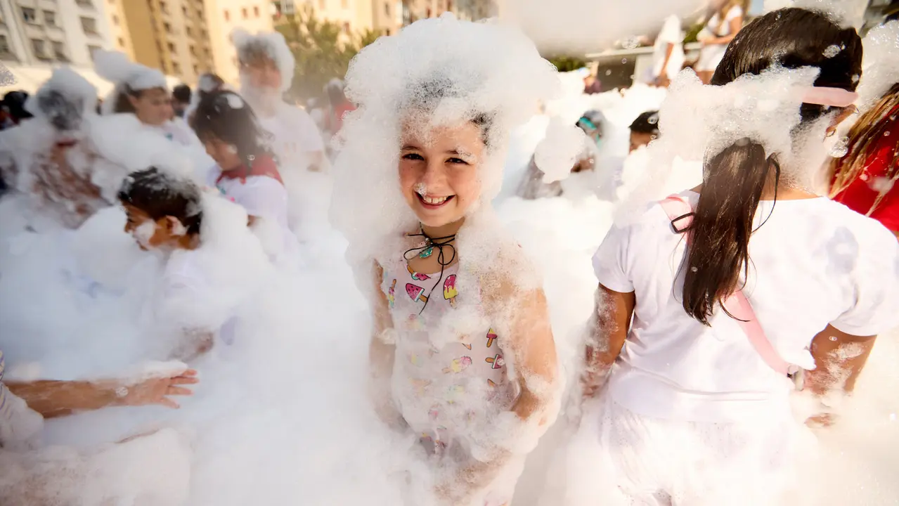 Niños y niñas juegan en la fiesta de la espuma tras el chupinazo de inicio de las Fiestas de Burlada 2025. IÑIGO ALZUGARAY
