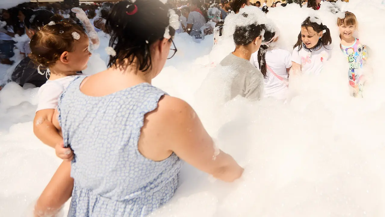 Niños y niñas juegan en la fiesta de la espuma tras el chupinazo de inicio de las Fiestas de Burlada 2025. IÑIGO ALZUGARAY
