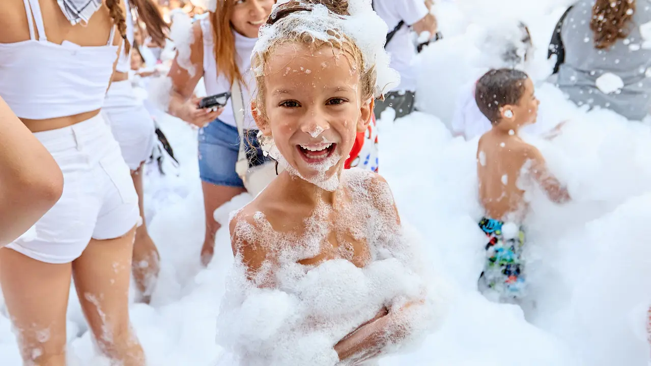 Niños y niñas juegan en la fiesta de la espuma tras el chupinazo de inicio de las Fiestas de Burlada 2025. IÑIGO ALZUGARAY