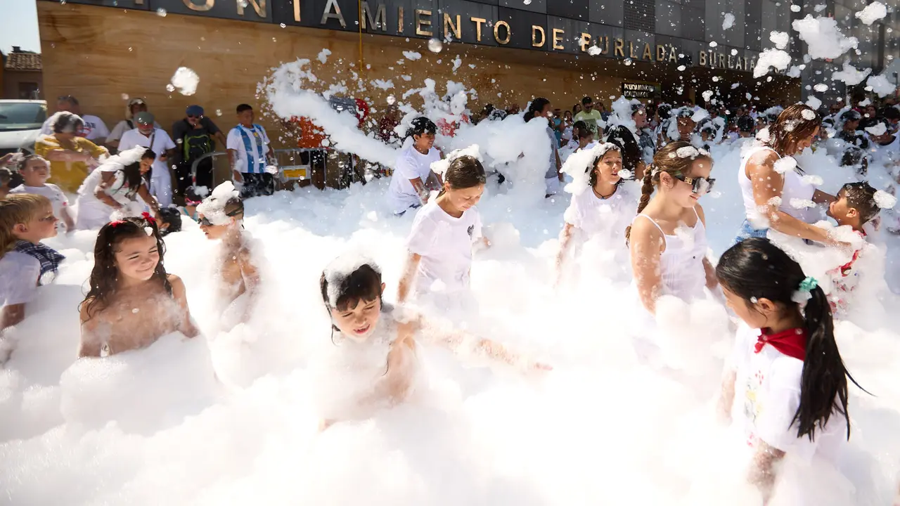 Niños y niñas juegan en la fiesta de la espuma tras el chupinazo de inicio de las Fiestas de Burlada 2025. IÑIGO ALZUGARAY