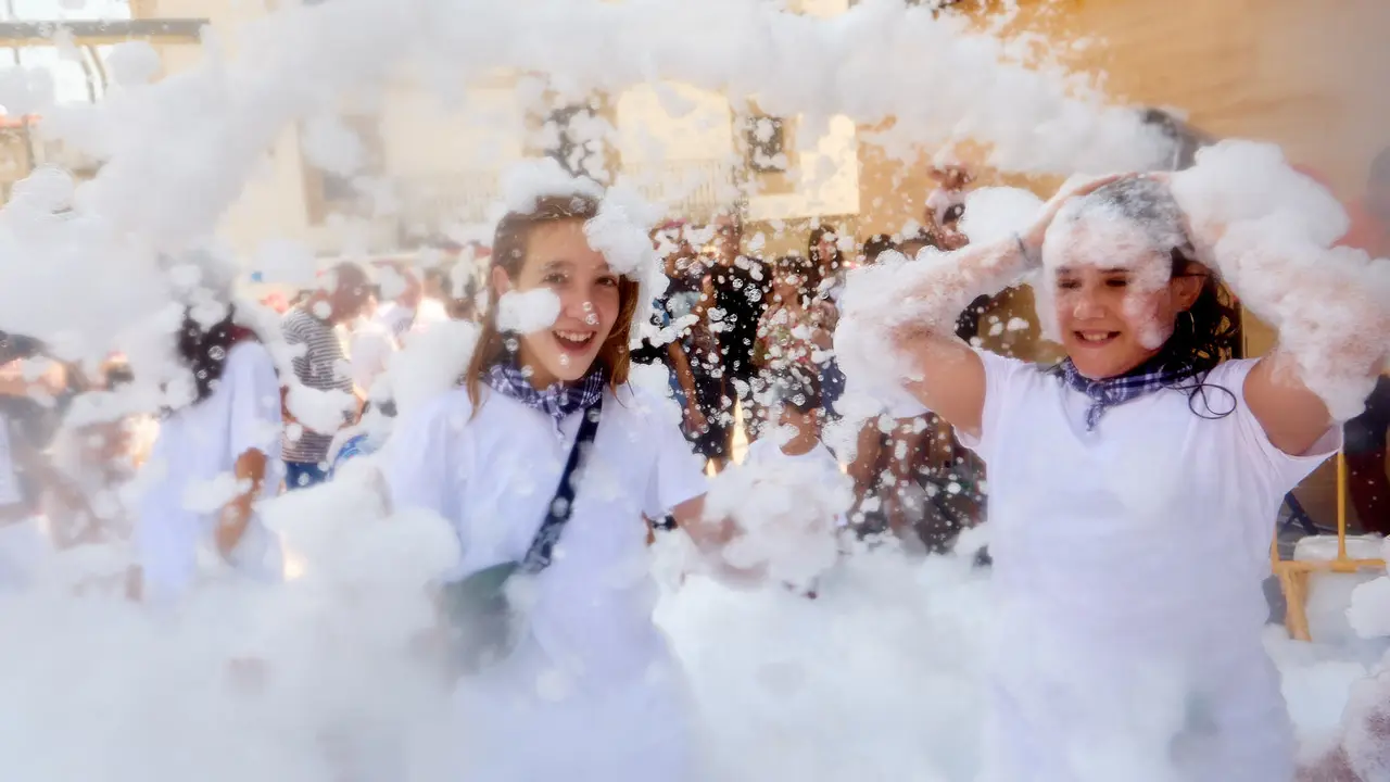 Niños y niñas juegan en la fiesta de la espuma tras el chupinazo de inicio de las Fiestas de Burlada 2025. IÑIGO ALZUGARAY