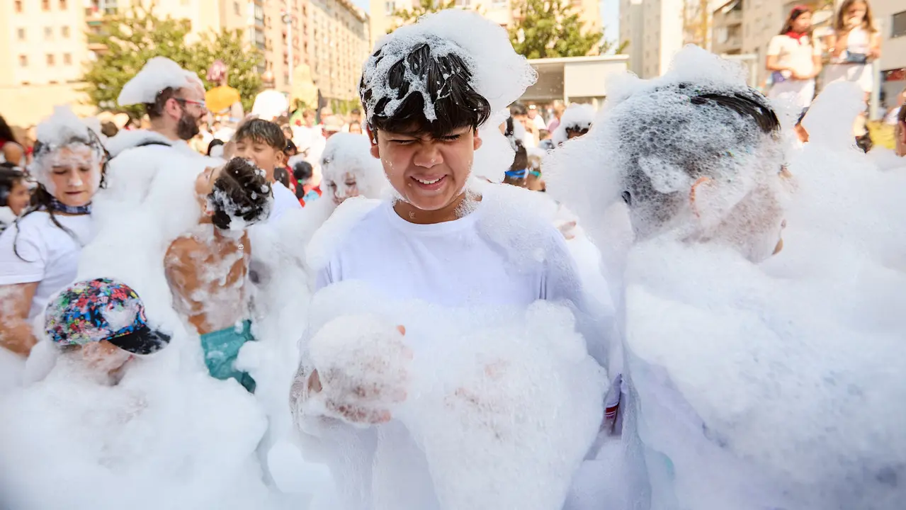 Niños y niñas juegan en la fiesta de la espuma tras el chupinazo de inicio de las Fiestas de Burlada 2025. IÑIGO ALZUGARAY