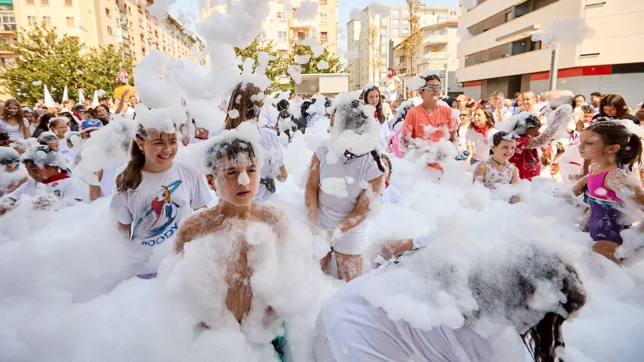 Niños y niñas juegan en la fiesta de la espuma tras el chupinazo de inicio de las Fiestas de Burlada 2025. IÑIGO ALZUGARAY