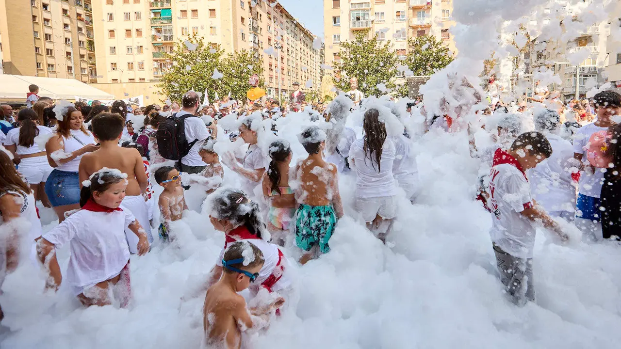 Niños y niñas juegan en la fiesta de la espuma tras el chupinazo de inicio de las Fiestas de Burlada 2025. IÑIGO ALZUGARAY