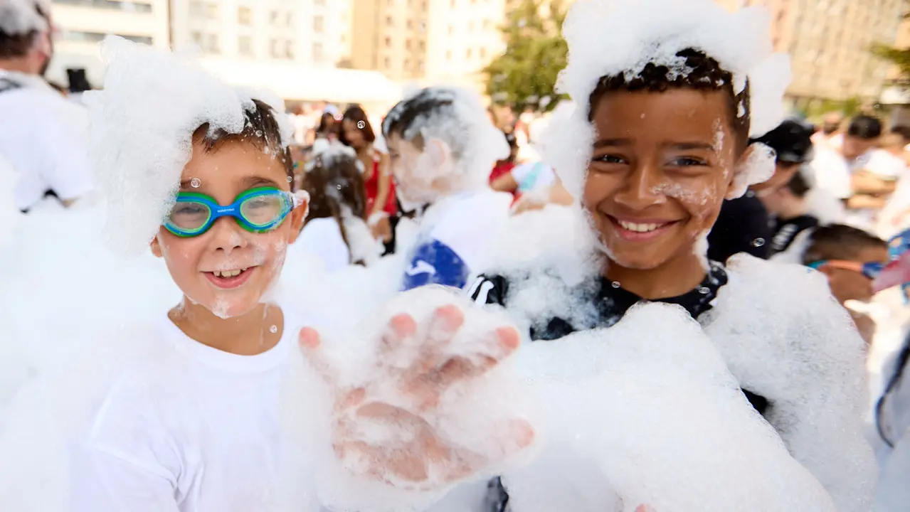 Niños y niñas juegan en la fiesta de la espuma tras el chupinazo de inicio de las Fiestas de Burlada 2025. IÑIGO ALZUGARAY
