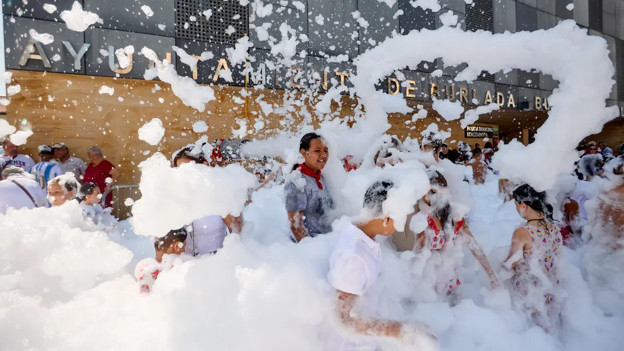 Niños y niñas juegan en la fiesta de la espuma tras el chupinazo de inicio de las Fiestas de Burlada 2025. IÑIGO ALZUGARAY
