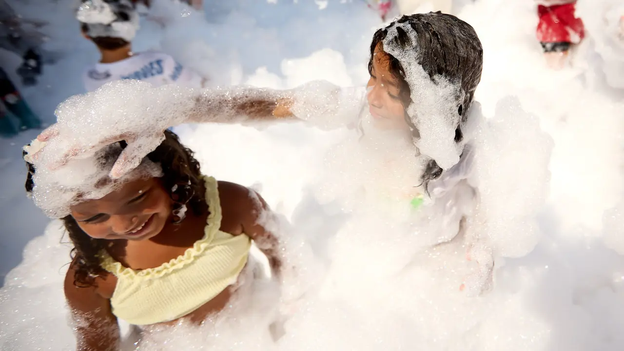 Niños y niñas juegan en la fiesta de la espuma tras el chupinazo de inicio de las Fiestas de Burlada 2025. IÑIGO ALZUGARAY