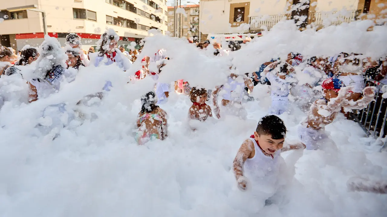 Niños y niñas juegan en la fiesta de la espuma tras el chupinazo de inicio de las Fiestas de Burlada 2025. IÑIGO ALZUGARAY