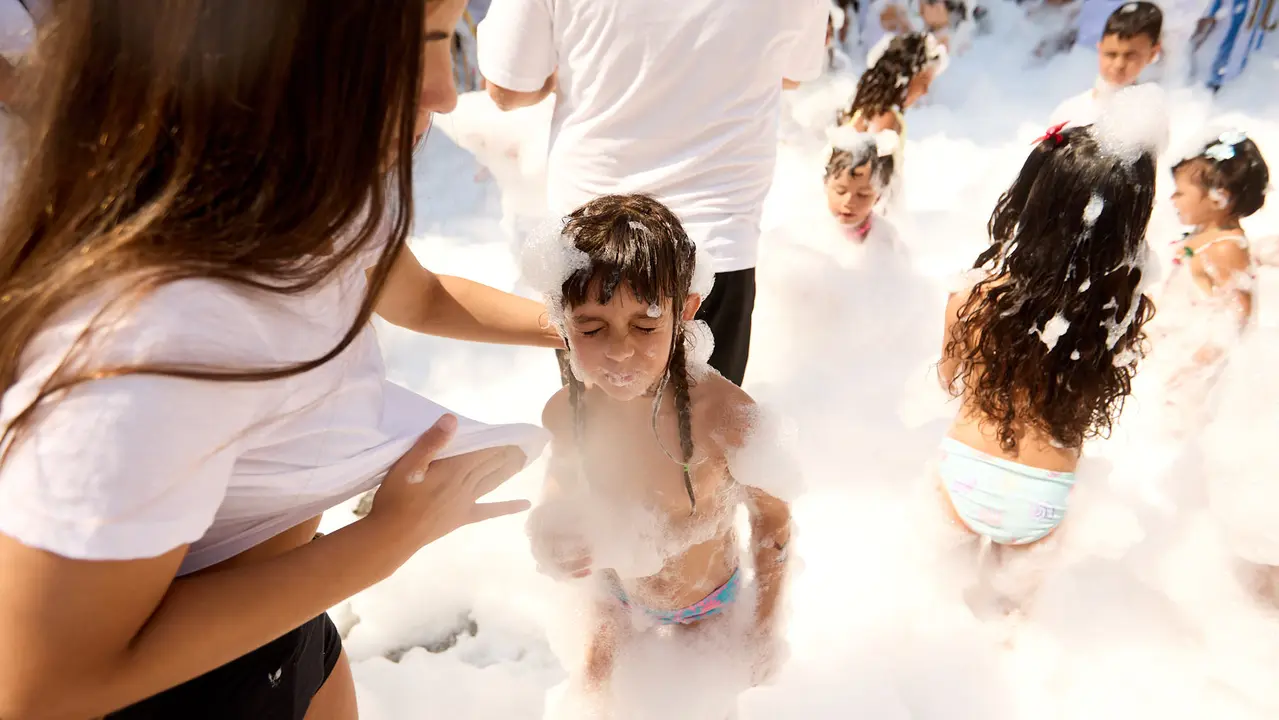 Niños y niñas juegan en la fiesta de la espuma tras el chupinazo de inicio de las Fiestas de Burlada 2025. IÑIGO ALZUGARAY