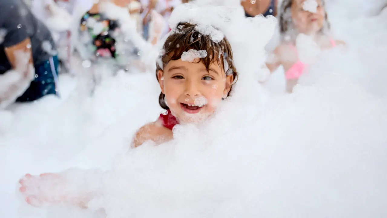 Niños y niñas juegan en la fiesta de la espuma tras el chupinazo de inicio de las Fiestas de Burlada 2025. IÑIGO ALZUGARAY