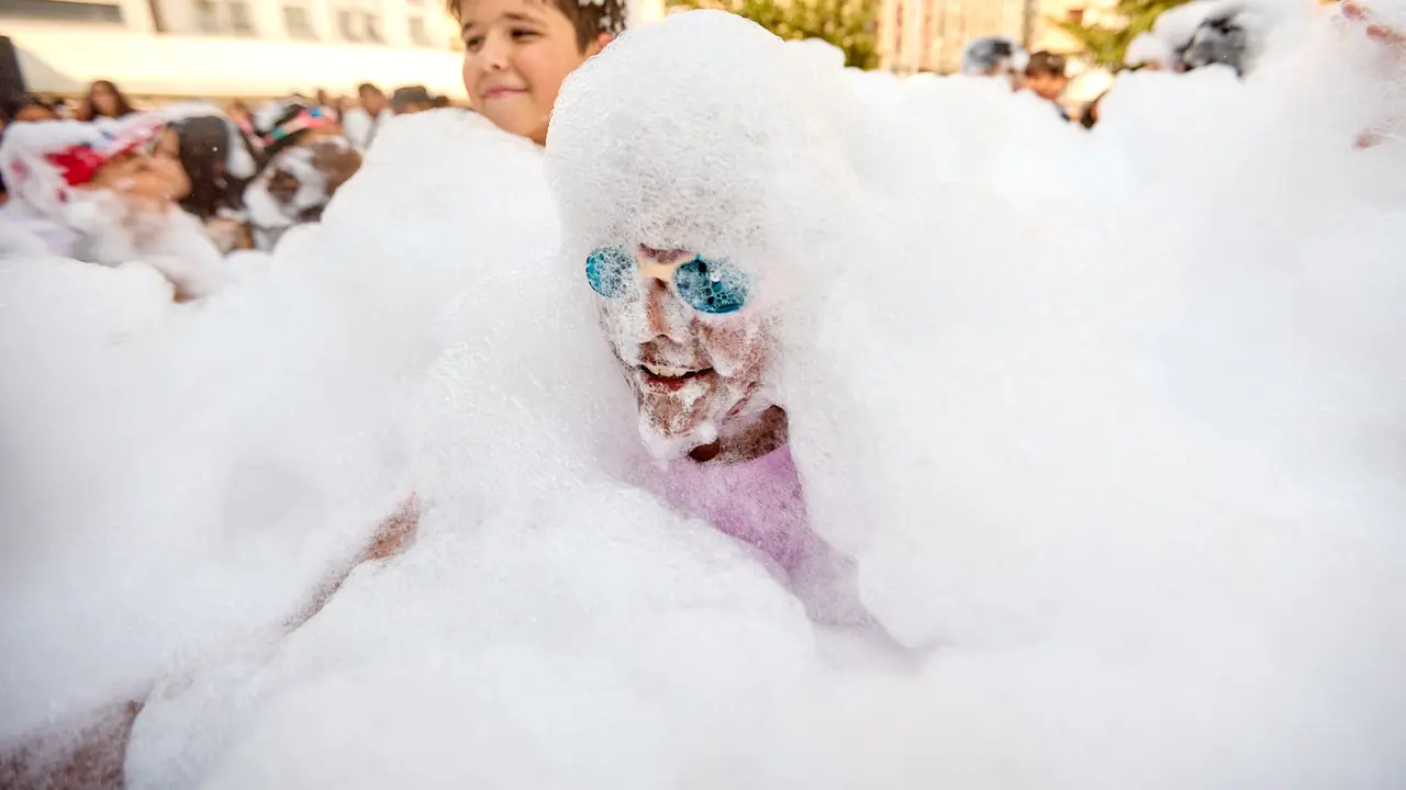 Niños y niñas juegan en la fiesta de la espuma tras el chupinazo de inicio de las Fiestas de Burlada 2025. IÑIGO ALZUGARAY