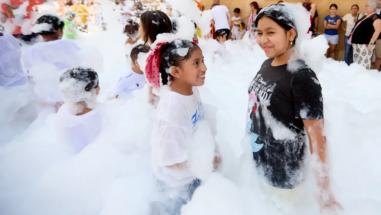 Niños y niñas juegan en la fiesta de la espuma tras el chupinazo de inicio de las Fiestas de Burlada 2025. IÑIGO ALZUGARAY